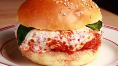 a close up of a sandwich on a plate with sesame seed crust and meatballs