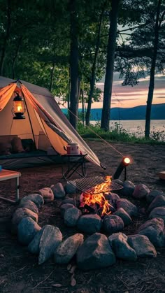 a tent is set up next to a campfire