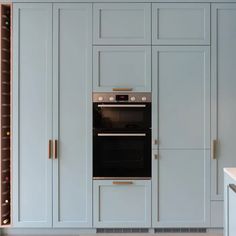 a kitchen with blue cabinets and an oven