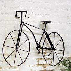 a bicycle hanging from the side of a brick wall next to a bowl of fruit