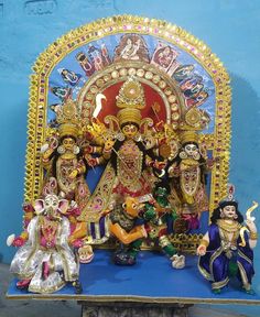 an idol is displayed in front of a blue wall with other figurines on it