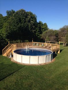 an above ground pool surrounded by grass and trees