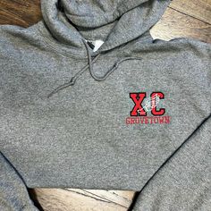 Elevate your training and race-day apparel with our premium hooded sweatshirt, featuring a detailed XC and track logo embroidered on the left chest. Personalize it with your team, coach, or player name to make a statement on and off the field. This sweatshirt blends functionality with team pride, offering the perfect combination of warmth and style for all cross country enthusiasts. Whether you're hitting the trails or cheering from the sidelines, this sweatshirt keeps you cozy and showcases you Sports Cotton Hoodie With Embroidered Logo, Gray Varsity Hoodie For Sports, Sports Hoodie With Embroidered Logo, Gray Sporty Hoodie With Embroidered Logo, Sporty Gray Hoodie With Embroidered Logo, Varsity Hoodie With Embroidered Logo For Sports Season, Embroidered Logo Hooded Sweatshirt For Sports Events, College Fan Apparel Hoodie With Embroidered Logo, Sporty Hooded Sweatshirt With Embroidered Graphics