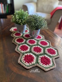 two crocheted pot holders on a table with plants in them and the word hello written across the top