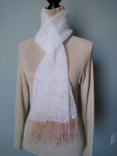 This gorgeous scarf is made with white superfine Kid Mohair that has a opalescent Lurex thread running throughout which adds subtle sparkle. I incorporated high quality pink glass seed beads that I  knitted into the pattern. The ends are trimmed with pink and metallic gold fringe.  Gorgeous gift for someone you love or beautiful addition to your wardrobe. Ships for free in a lovely sheer Organza gift bag. Entirely handmade in my smoke free home studio. Due to the delicate fibers and beads, I recommend dry cleaning. Be sure to tell your dry cleaner: do NOT press.  This scarf is fabulous.  Made with love by Love. Luxury Mohair Scarves For Fall, Elegant Handmade Mohair Shawl, Winter Mohair Shawl Scarf, Hand-knitted Mohair Scarf For Winter, Handmade Mohair Shawl Scarf, Beaded Scarf, Mohair Scarf, Gold Fringe, Cute Scarfs