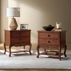 two wooden nightstands sitting next to each other on top of a carpeted floor