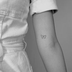 a woman's arm with a butterfly tattoo on the left side of her arm