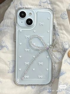 an iphone case with a bow on the back is laying on top of a blanket