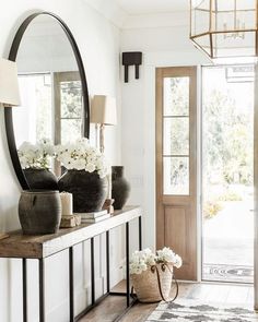 A large round mirror is mounted on a white wall over a wood and metal console table lit by pretty brass sconces with white shades. Contemporary Entryway Ideas, Stairs Entryway, Ideas Entryway, Contemporary Entryway, Bench Entryway, Small Entrance, Interior Design Per La Casa, Modern Entryway