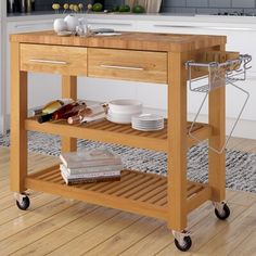 a kitchen island cart with plates and bowls on it in the middle of a wooden floor