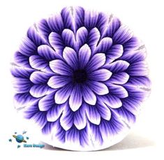 a purple and white flower is in the middle of a circular design on a plate