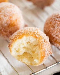 sugar coated doughnuts sitting on a cooling rack