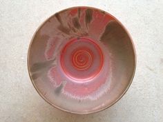 a red bowl sitting on top of a white counter