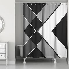 a black and white shower curtain hanging in a bathroom next to a dresser with a mirror on it