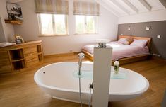 a large white bath tub sitting inside of a bedroom