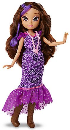 the doll is wearing a purple dress with polka dots on it and has long brown hair