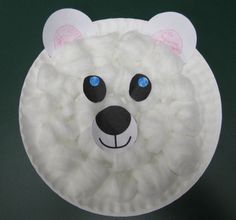 a paper plate with a white polar bear face on it's side and blue eyes