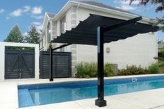 an outdoor swimming pool with a pergolated cover over it and a house in the background