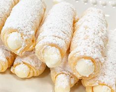 powdered sugar covered pastries on a white plate