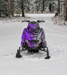 a purple and black snowmobile in the snow