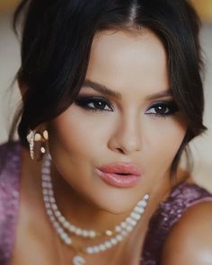 a close up of a woman wearing pearls