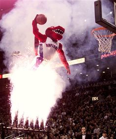 an inflatable basketball player dunks the ball into the air during a game