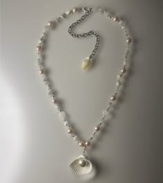 a necklace with pearls and a shell on it