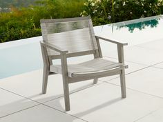 a gray chair sitting on top of a white tile floor next to a swimming pool