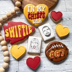 decorated cookies are arranged in the shape of heart and footballs, with words on them