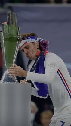 a female tennis player is holding the trophy in her hand and looking down at it