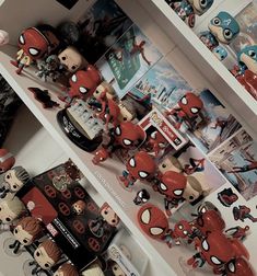 many spider - man figurines are displayed on shelves