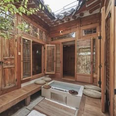 an indoor hot tub in the middle of a room with wood paneling and windows