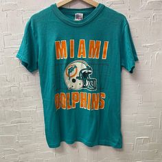 Vintage Miami Dolphins 52 T-Shirt | Vintage Graphic T-Shirt | Miami Dolphins Tee | Football T-Shirt | Size L | SKU NPC-1282 | Used - Stains on middle right front, center front, and upper left back. Cracking on front graphic. Holes on center and left front.  L Size for Men, Please refer to photos for measurements Chest 19" Length 25 1/2" Cotton Polyester We only ship to the US and Canada. All our items of vintage condition. Most of the items have minor defects such as holes, stains, cracking on t Back Cracking, Vintage Miami, Football T Shirt, Vintage Graphic, Miami Dolphins, Vintage Graphics, Dolphins, Graphic T Shirt, Miami