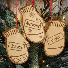 three wooden mittens hanging from a christmas tree