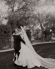 a bride and groom embracing each other outside