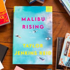 a book sitting on top of a wooden table next to bookshelves and other items