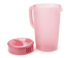 a pink plastic pitcher next to a cup on a white background