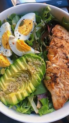 a salad with salmon, avocado and hard boiled eggs in it that says eat dinner