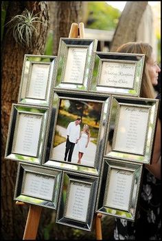 a group of framed pictures sitting on top of a wooden easel