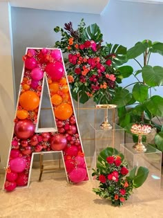 the letters are made out of fruit and flowers in front of some other decorations on display