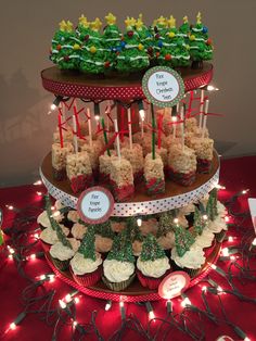 cupcakes are stacked on top of each other in front of christmas decorations and lit candles