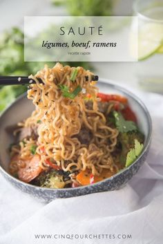 a bowl filled with noodles and vegetables on top of a table