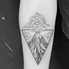 a man's leg with a mountain and clouds tattoo on the side of his arm