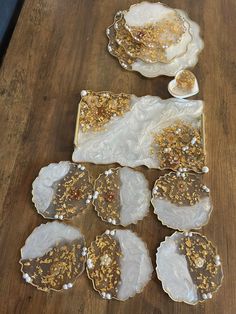 several plates and bowls are sitting on a wooden table with gold sprinkles