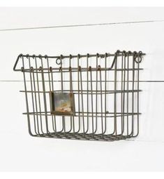 a metal basket hanging on the side of a wall