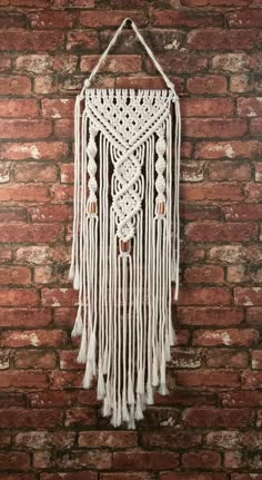 a white macrame hanging on a brick wall