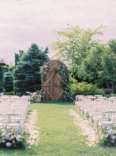 an outdoor ceremony set up with white chairs