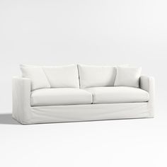 a white couch sitting on top of a white floor