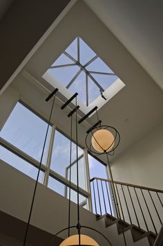 the light fixture is hanging from the ceiling above the stairs in this modern style home