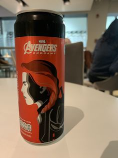 a can of avengers endgame on a table with people in the backgroud